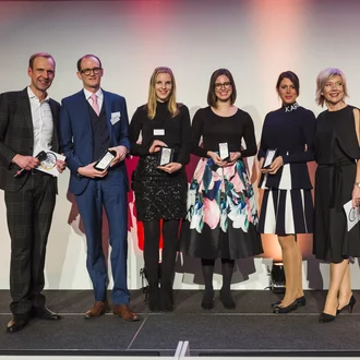 Gruppenfoto der Exzellenzpreis-Preisträger 2019 – sieben ausgezeichnete Fach- und Führungskräfte mit Award auf Bühne, festlich gekleidet, feierliche Galaatmosphäre