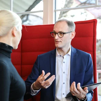 Gespräch zwischen Denkströme Geschäftsführerin und Geschäftsführer in moderner Bürolounge – professioneller Austausch über Strategie oder Projektplanung