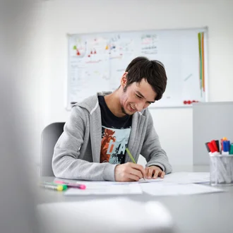 Junger Denkströme Grafiker arbeitet konzentriert an Markenentwürfen im kreativen Büro der Denkströme Gruppe