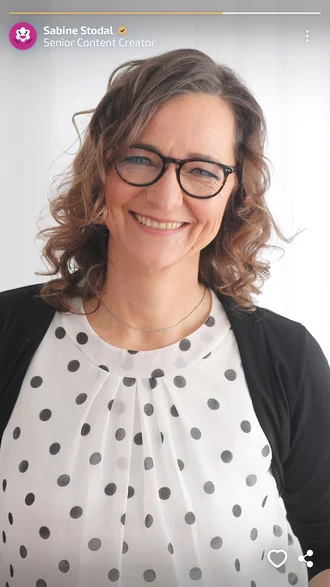 Sabine Stodal, Senior Content Creator bei Denkströme, freundlich lächelnd im Porträt mit gepunkteter Bluse und Brille