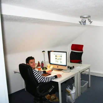 Designer arbeitet 2010 im Dachgeschossbüro bei schmiddesign an einem iMac mit Grafiksoftware